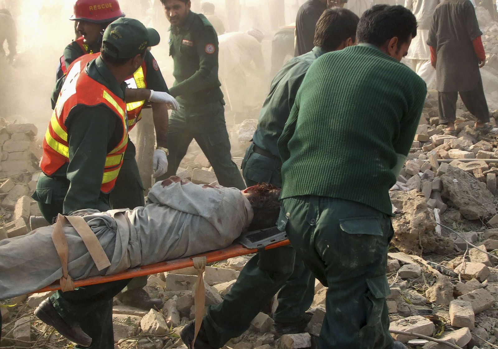 Rescue workers remove a body from the site of a car bomb attack in Dera Ghazi Khan