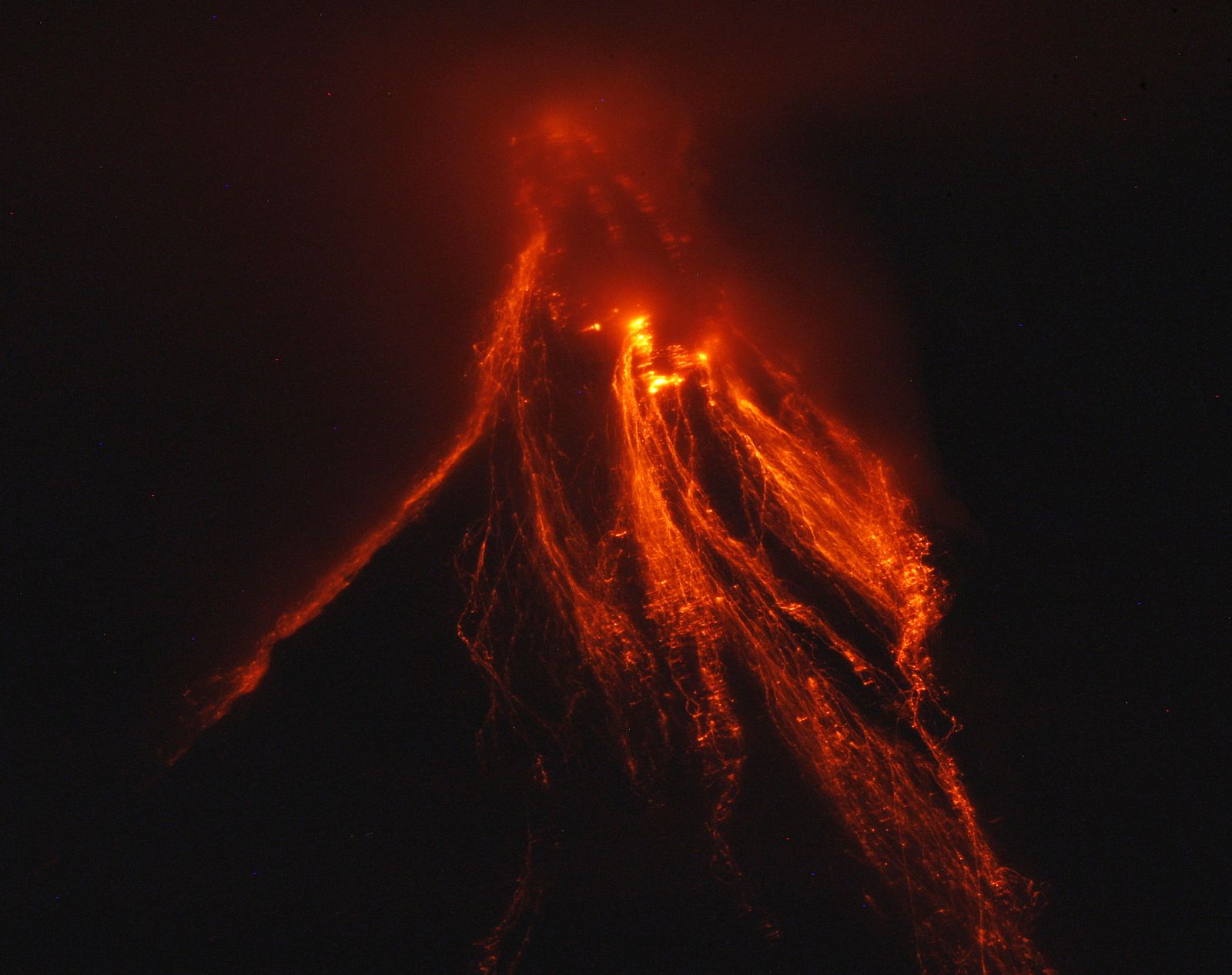 Lava glows while cascading on the slopes of Mayon volcano as seen from Lingnon Hill in Legazpi city
