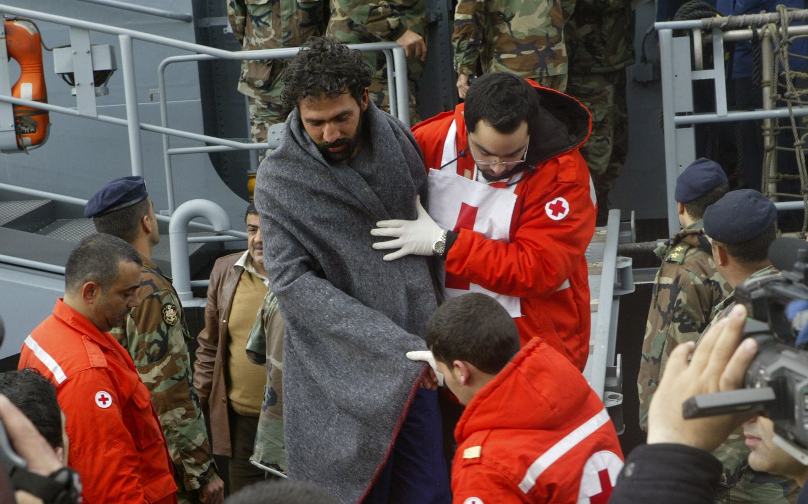 Los equipos de rescate libaneses ayudan a uno de los supervivientes del naufragio del Danny FII