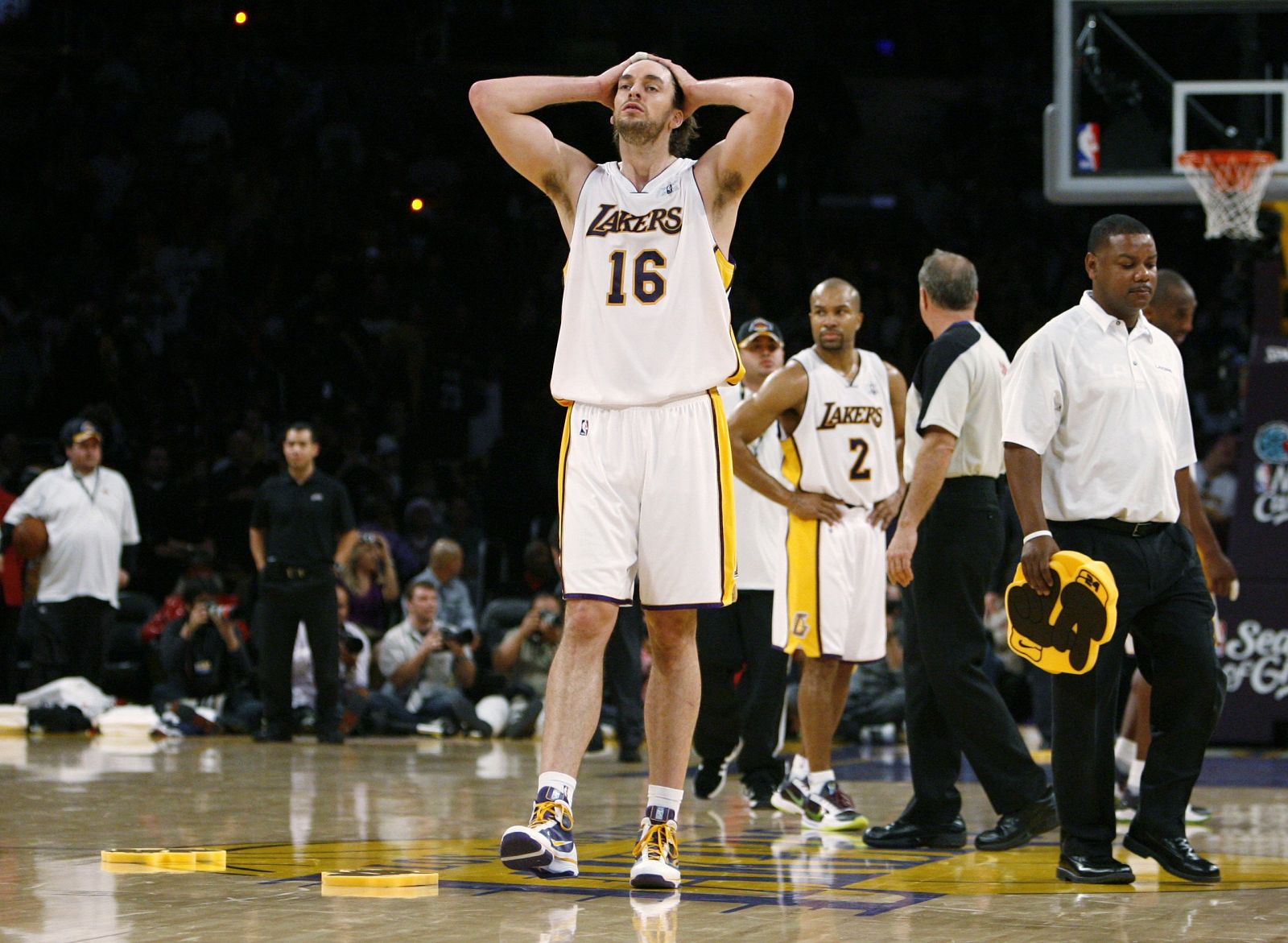 Los Angeles Lakers' Gasol and Fisher react as a man picks up a foam hand after fans threw them onto the court against the Cleveland Cavaliers in Los Angeles