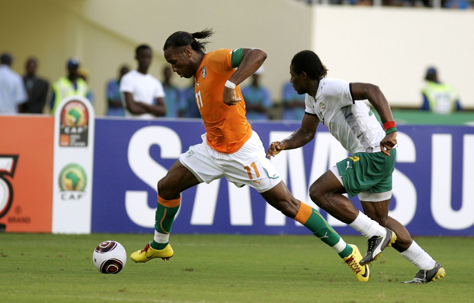 El delantero marfileño, Didier Drogba, conduce el balón ante un defensor de Burkina Faso