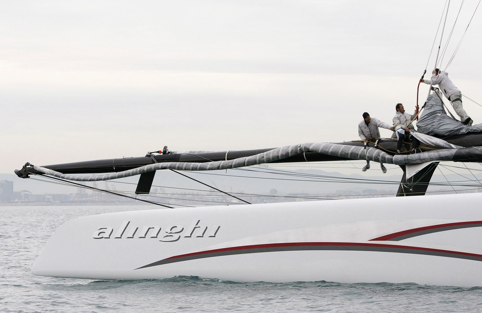 Crew members of Americas Cup defender Alinghi raise a sail during a training session at the coast of Valencia