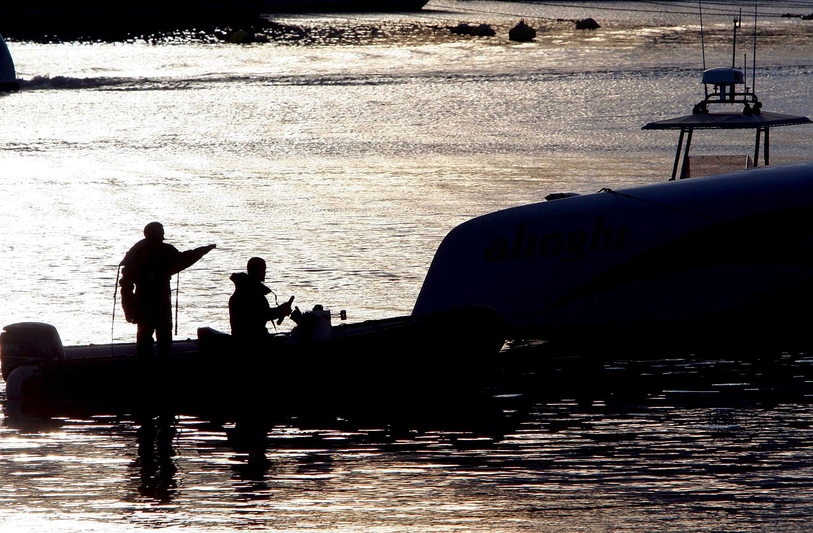 Miembros de la tripulación del catamarán suizo Alinghi dan los últimos retoques a su embarcación.
