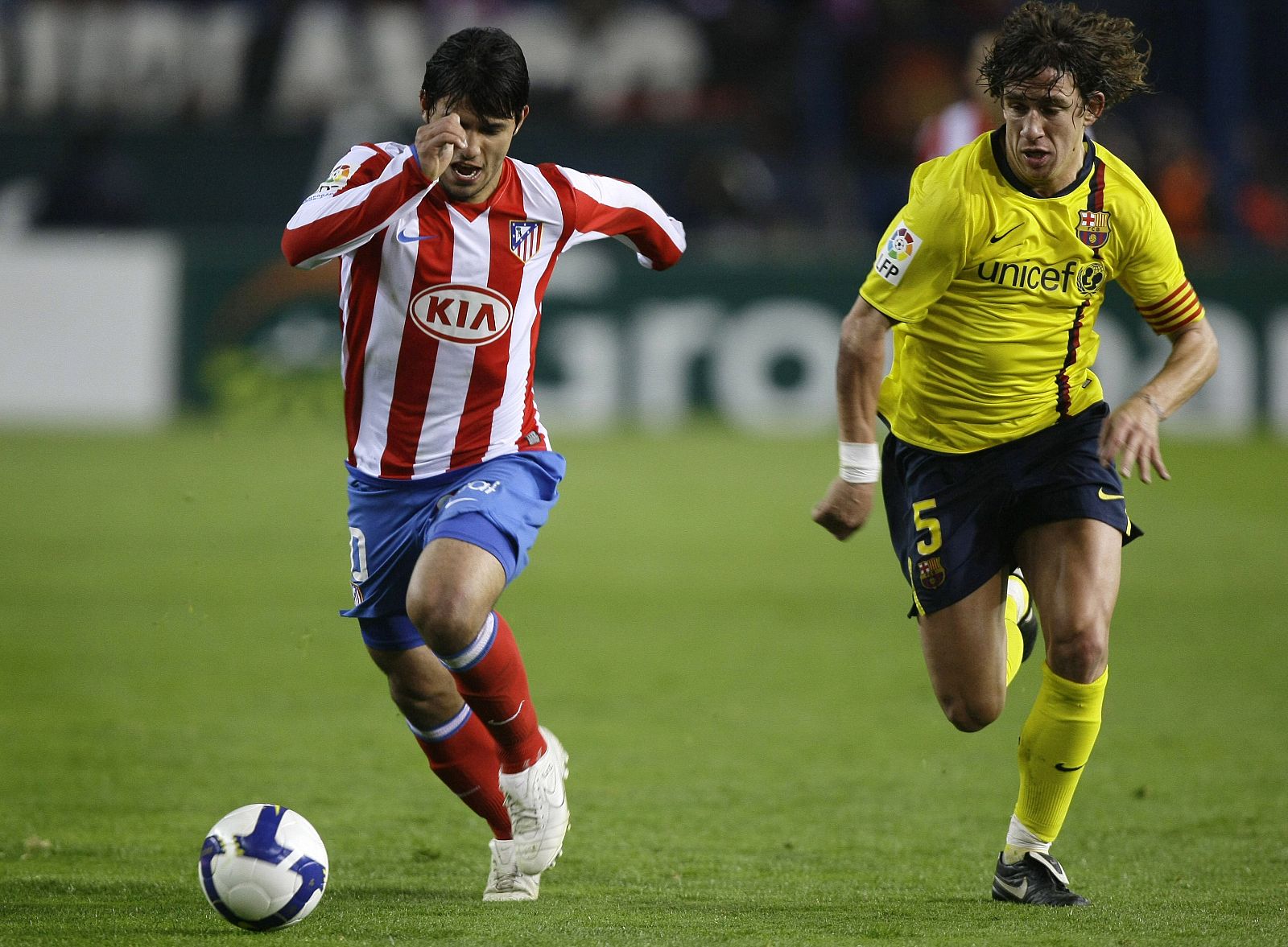 Atletico Madrid's Aguero gets past Barcelona's Puyol during their Spanish first division match  in Madrid
