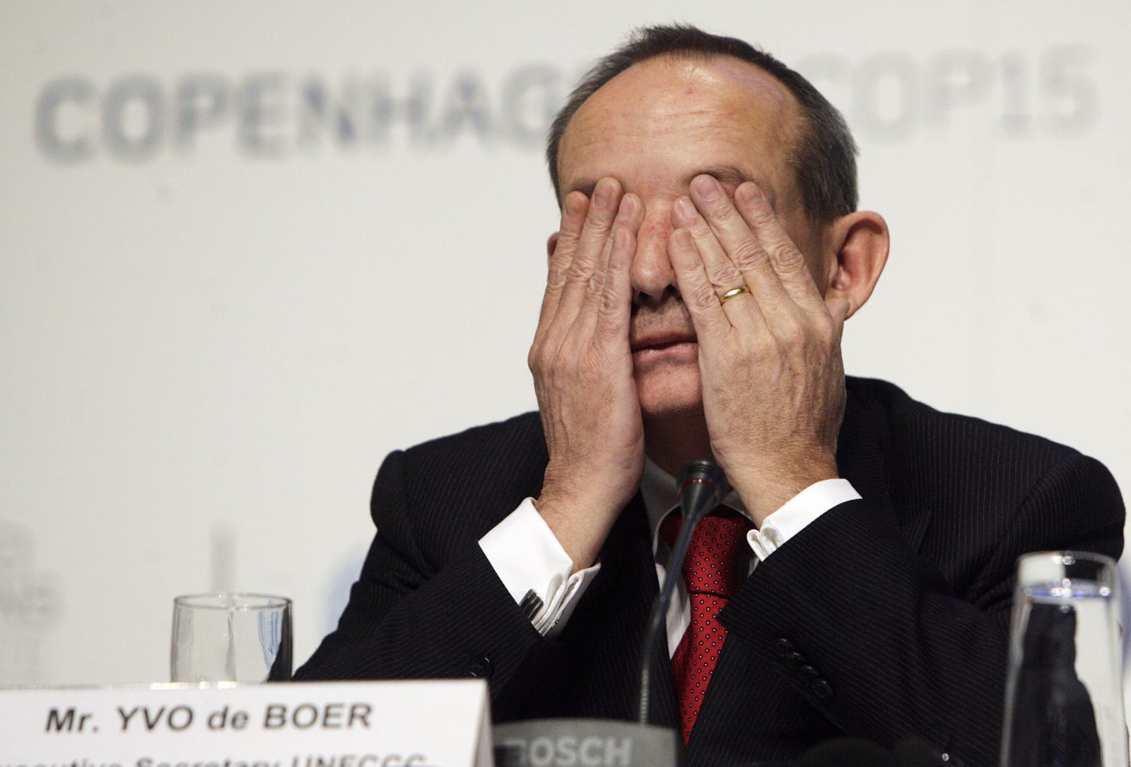Yvo de Boer covers his eyes as he attends a news conference at the United Nations Climate Change Conference 2009 in Copenhagen