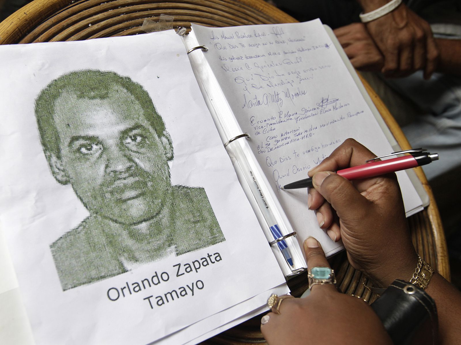 A woman signs a condolence book for jailed Cuban activist Orlando Zapata Tamayo in Havana
