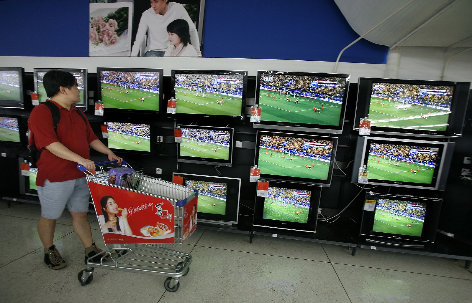 A Chinese shopper watches a replay of Euro 2008 in Beijing