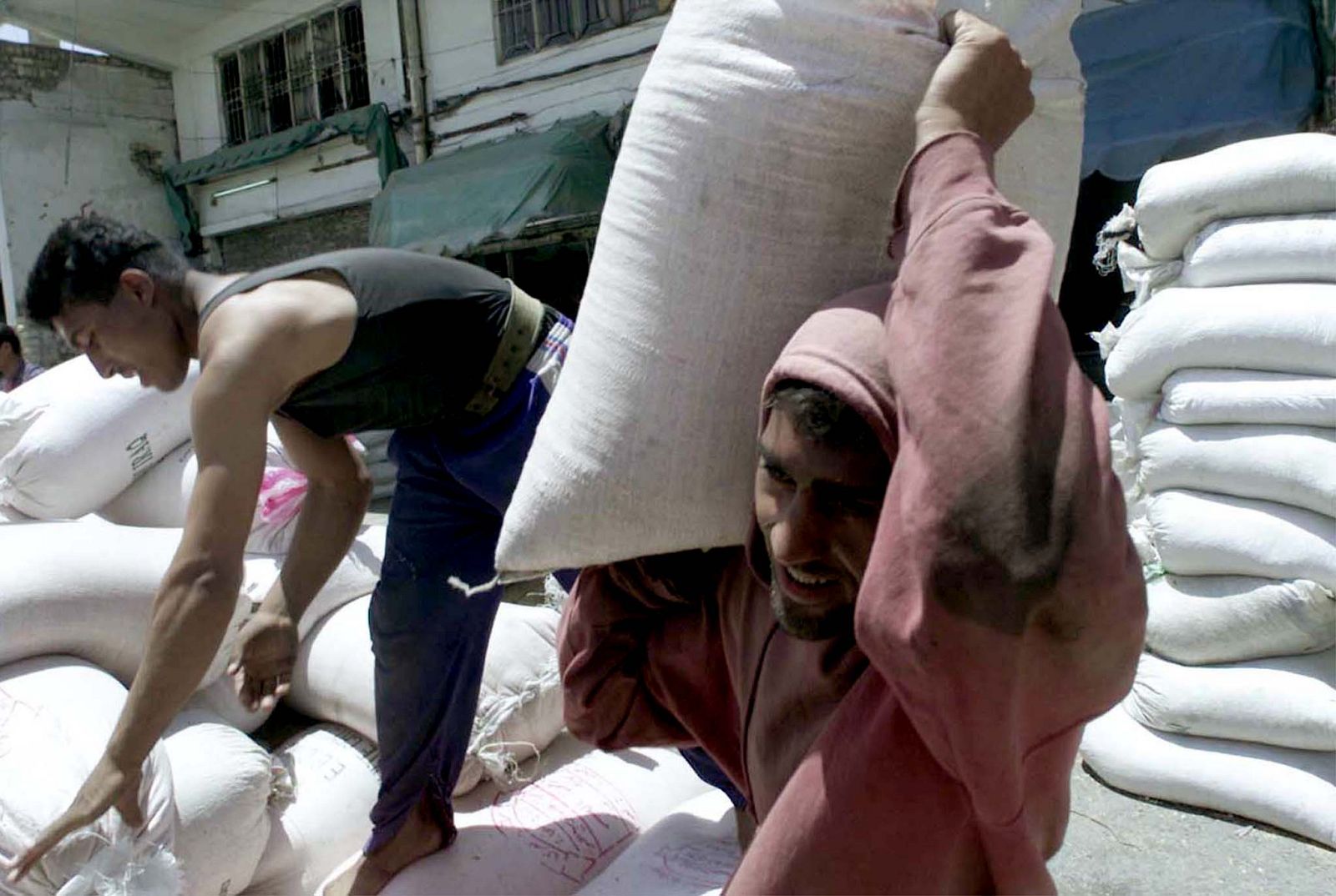 IRAQI WORKERS UNLOAD RATION FLOUR IMPORTED BY TRADE MINISTRY IN BAGHDAD.