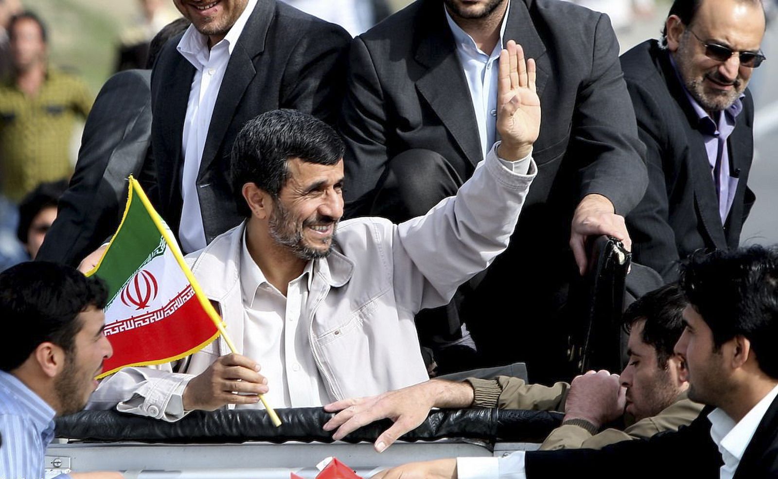 Iran's President Mahmoud Ahmadinejad holds a flag as he waves to his supporters during his provincial trip to Orumieh
