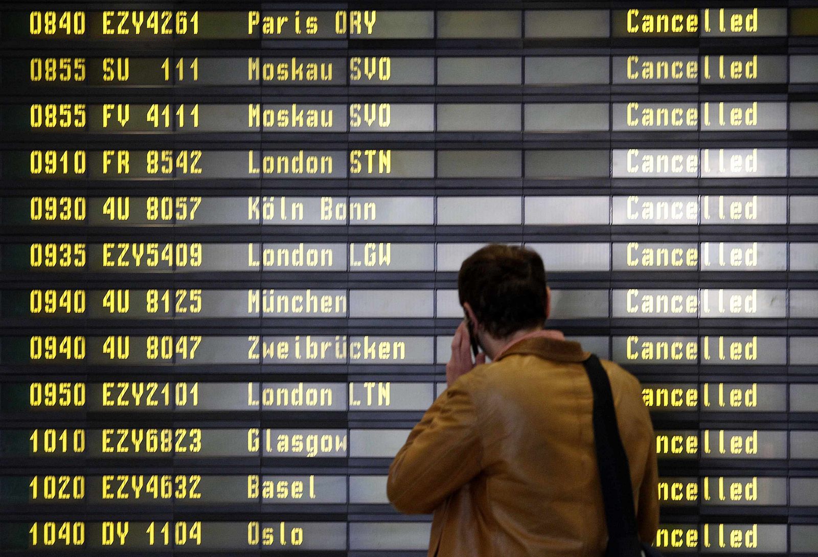 Man reads information board at departure hall of Berlin's Schoenefeld airport