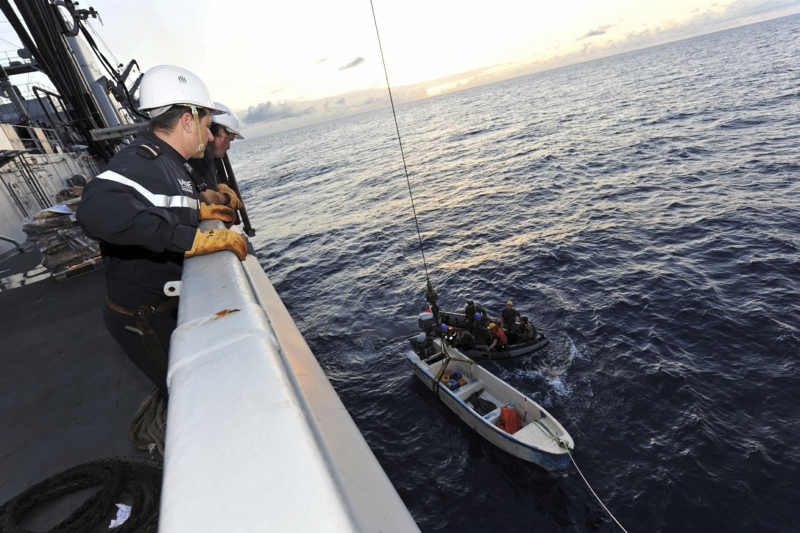 Los marineros del buque de la Armada francesa "La Somme" se preparan para levantar una pequeña nave frente a las costas de Somalia, después de un ataque pirata durante la noche.