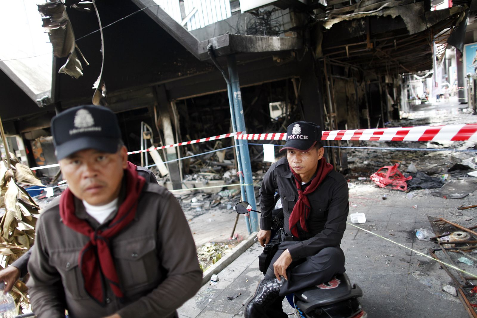 Policías tailandeses junto a uno de los edificios incendiados