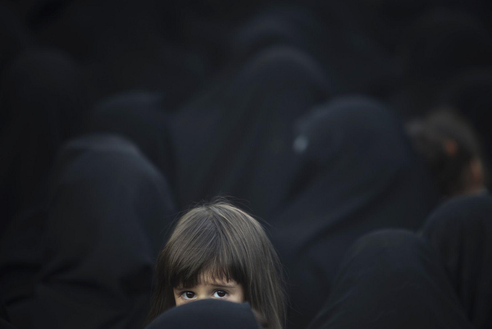 Iranian young girl looks on as she and her mother attend at religious ceremony to commemorate death anniversary of Fatima in southern Tehran