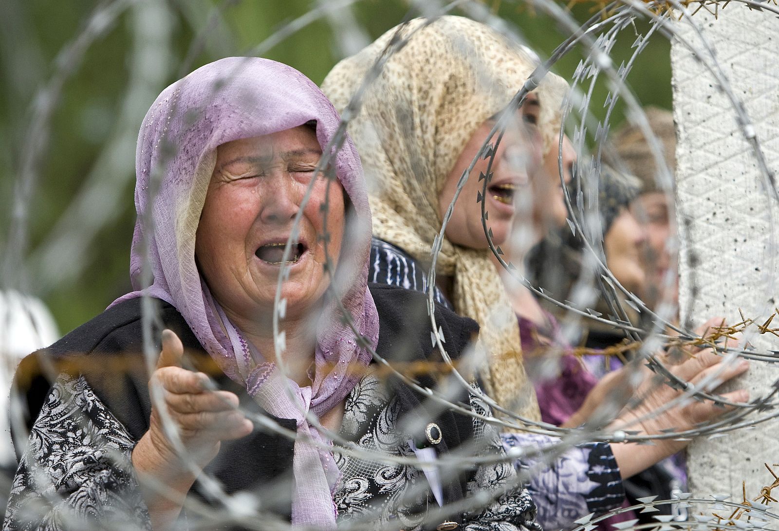 Ethnic Uzbek refugees, fled from clashes in the city, cry as they gather on the Kyrgyz-Uzbek border, while waiting for permission to escape to Uzbekistan, near Osh, southern Kyrgyzstan