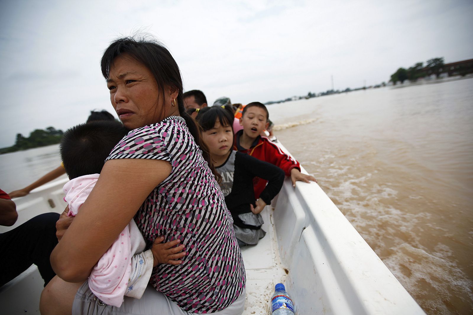 Flood victims sit in a rescue boat as they head towards a temporary shelter after being evacuated from flooded homes  in the outskirts of Yingtan