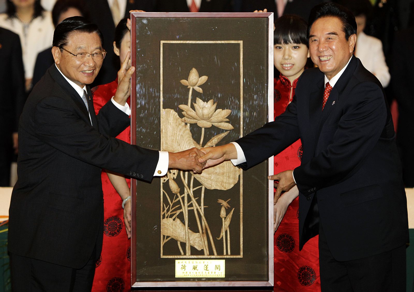 Taiwan's Straits Exchange Foundation (SEF) Chairman P.K. Chiang shakes hands with Chen Yunlin, Chairman of China's Association for Relations Across the Taiwan Straits (ARATS), in front of a gift  in Chongqing