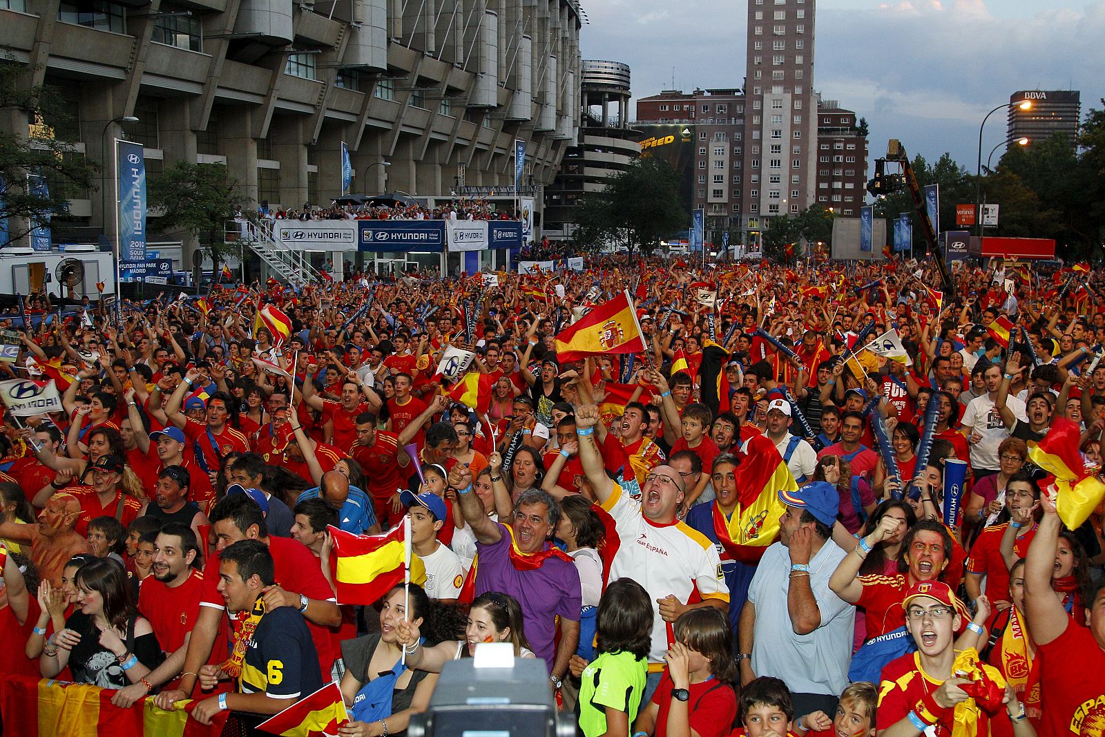 La afición española celebra el gol de España durante el partido frente a Paraguay desde la pantalla gigante instalada junto al estadio Santiago Bernabéu, en Madrid.