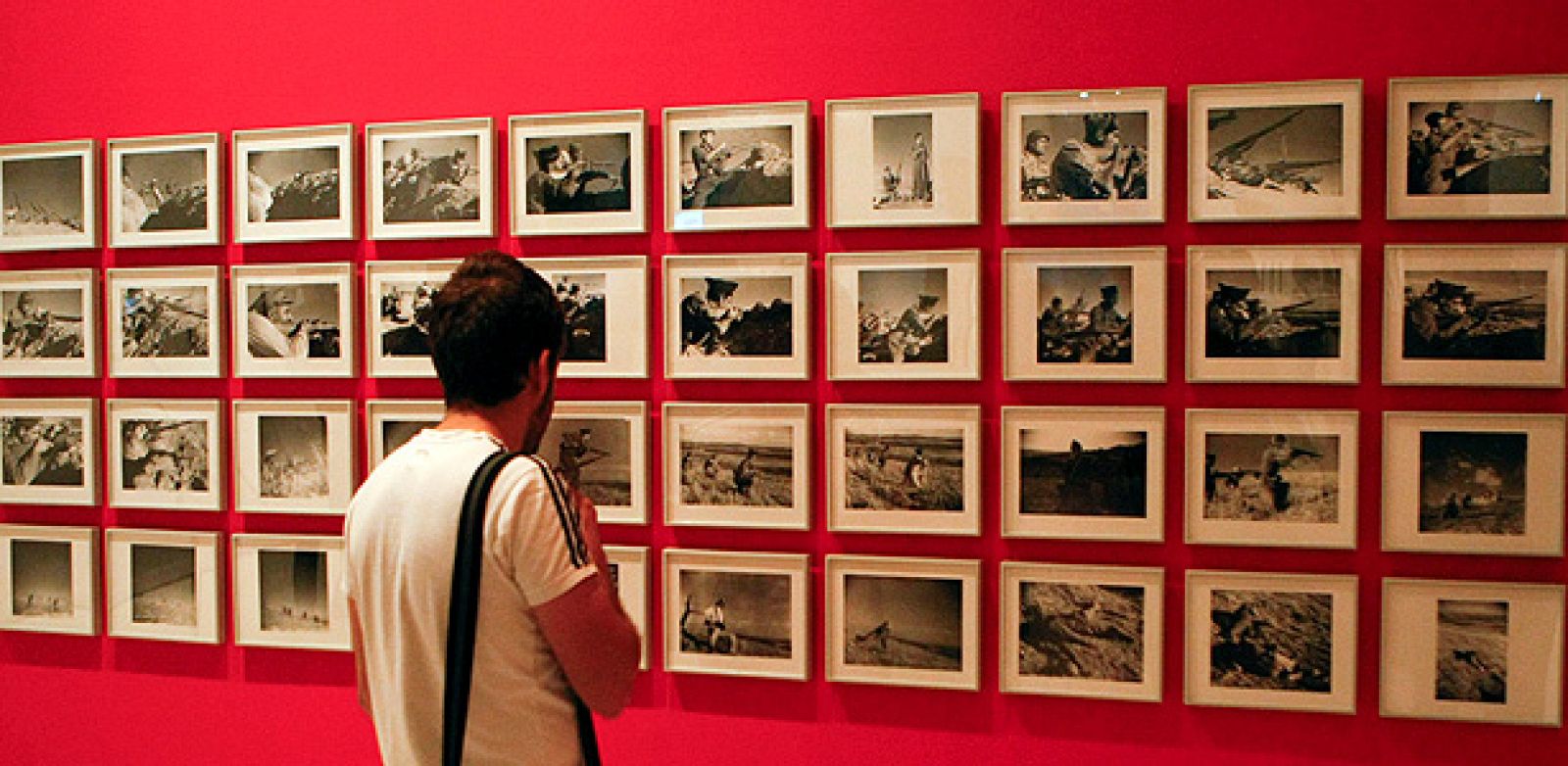 Un joven contempla fotografías de la exposición ¡Esto es la guerra!