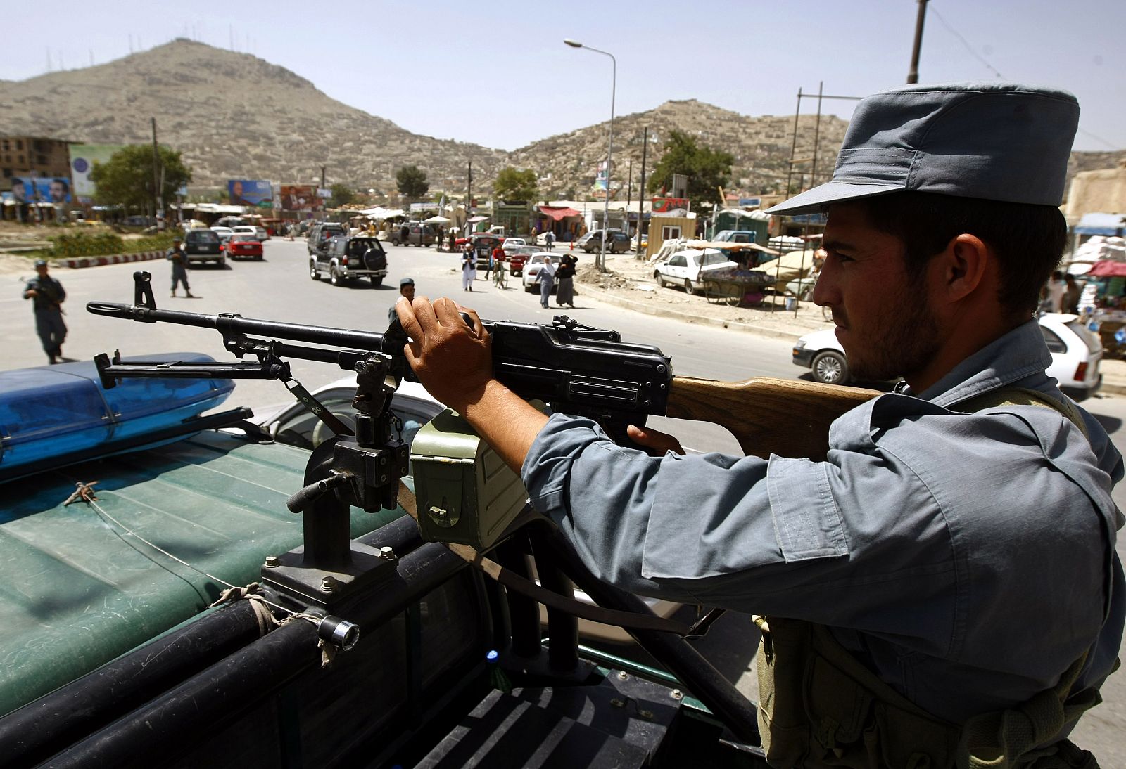Afghan policeman atop a vehicle keeps watch in Kabul