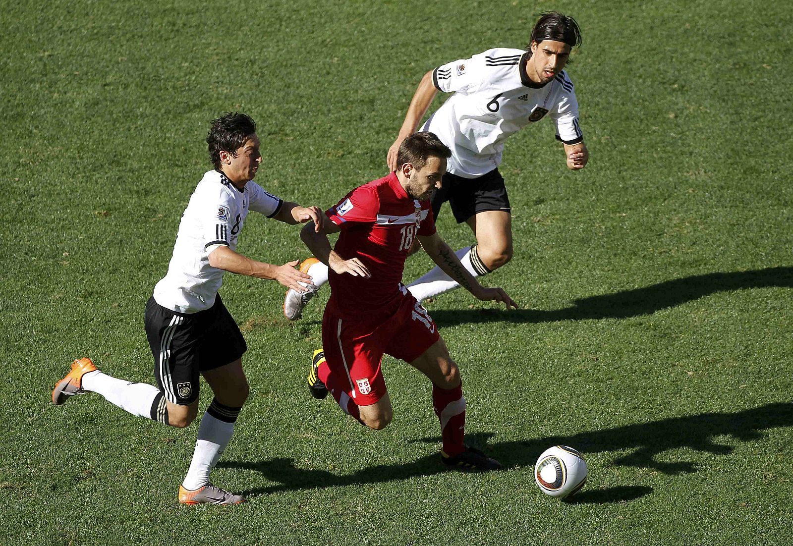 Serbia's Ninkovic runs for the ball with Germany's Ozil and Khedira during a 2010 World Cup Group D soccer match against Germany  in Port Elizabeth