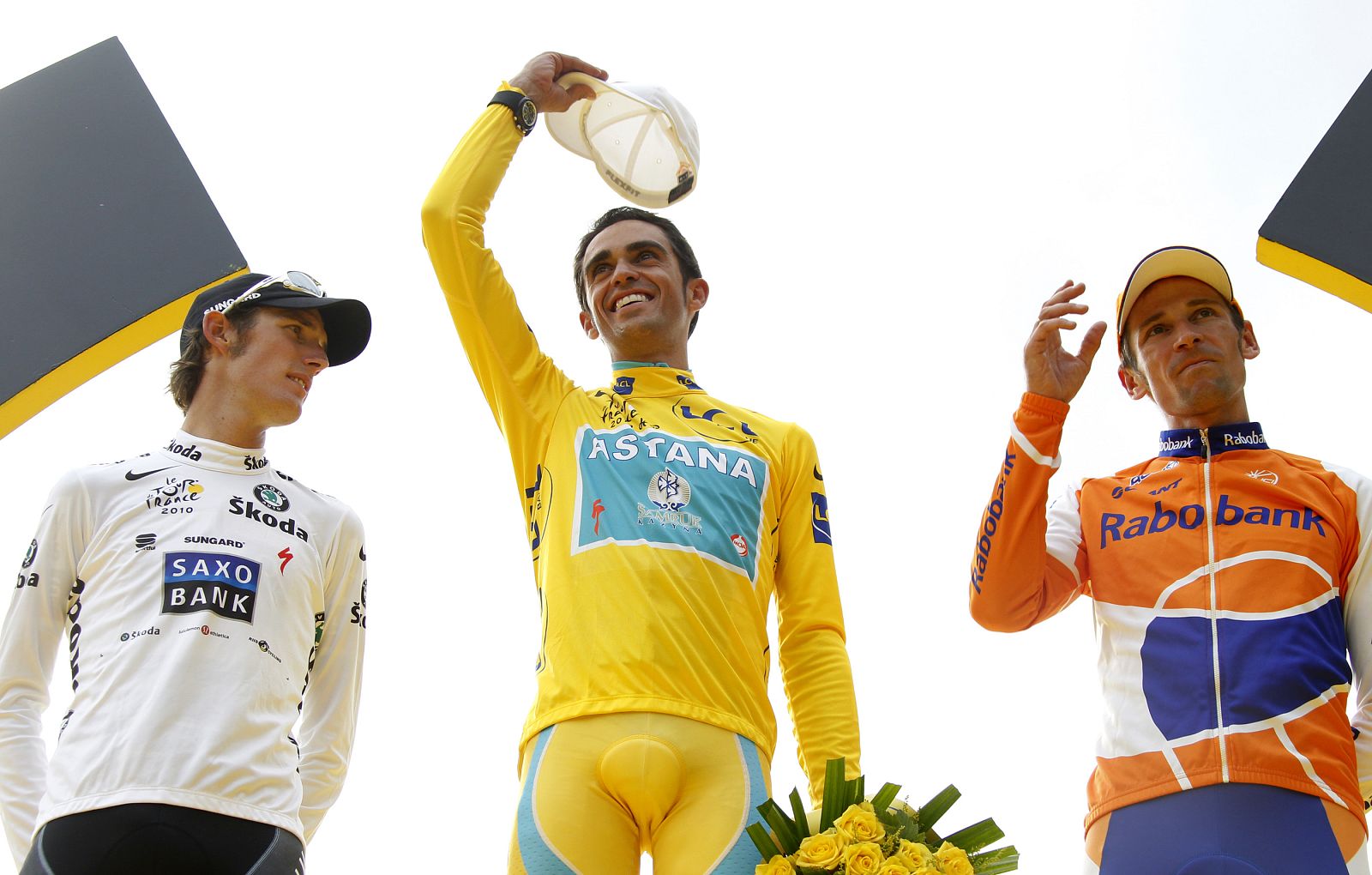 Astana team rider Alberto Contador of Spain celebrates surrounded by Saxo Bank team rider Andy Schleck of Luxembourg and Rabobank team rider Denis Menchov of Russia, on the podium final 20th stage of the 97th Tour de France cycling race between