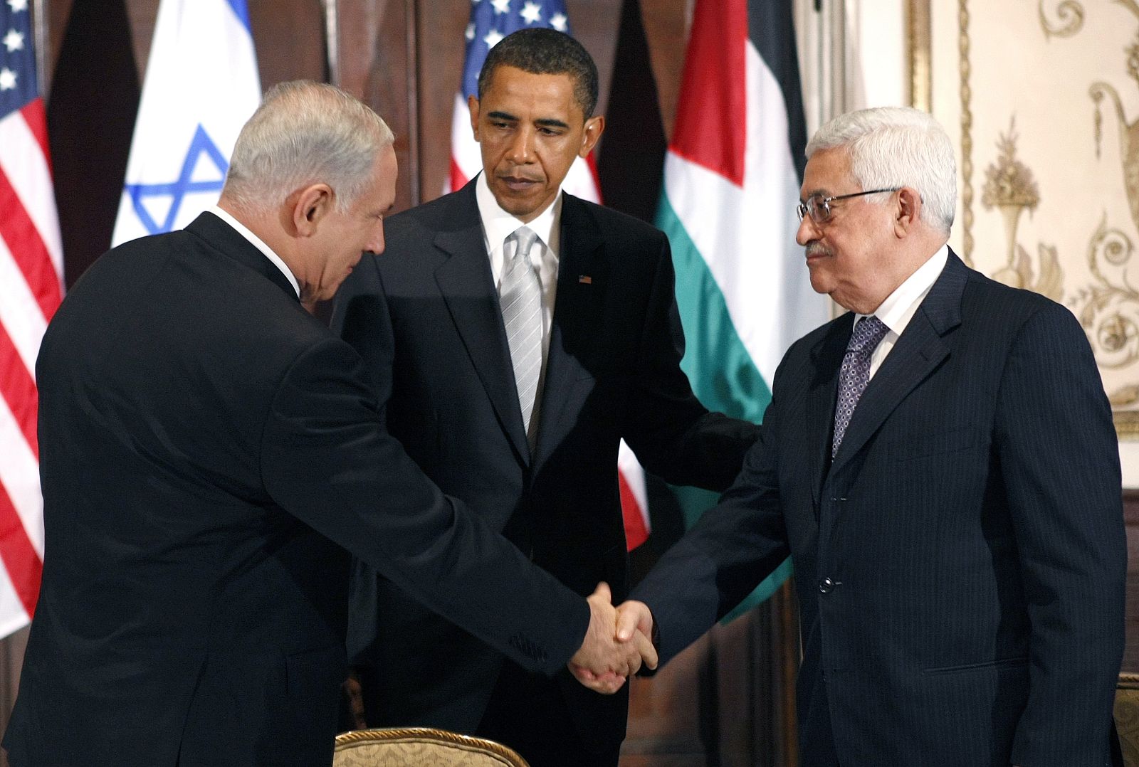 U.S. President Obama watches Israeli Prime Minister Netanyahu and Palestinian President Abbas shake hands during a trilateral meeting in New York