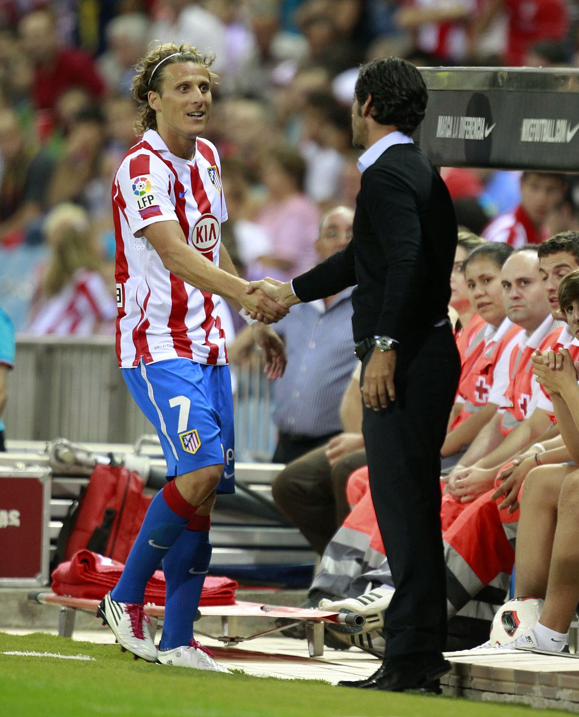 El técnico del Atlético de Madrid, Quique Sánchez Flores, da la mano a su delantero Forlán en el estadio Vicente Calderon.