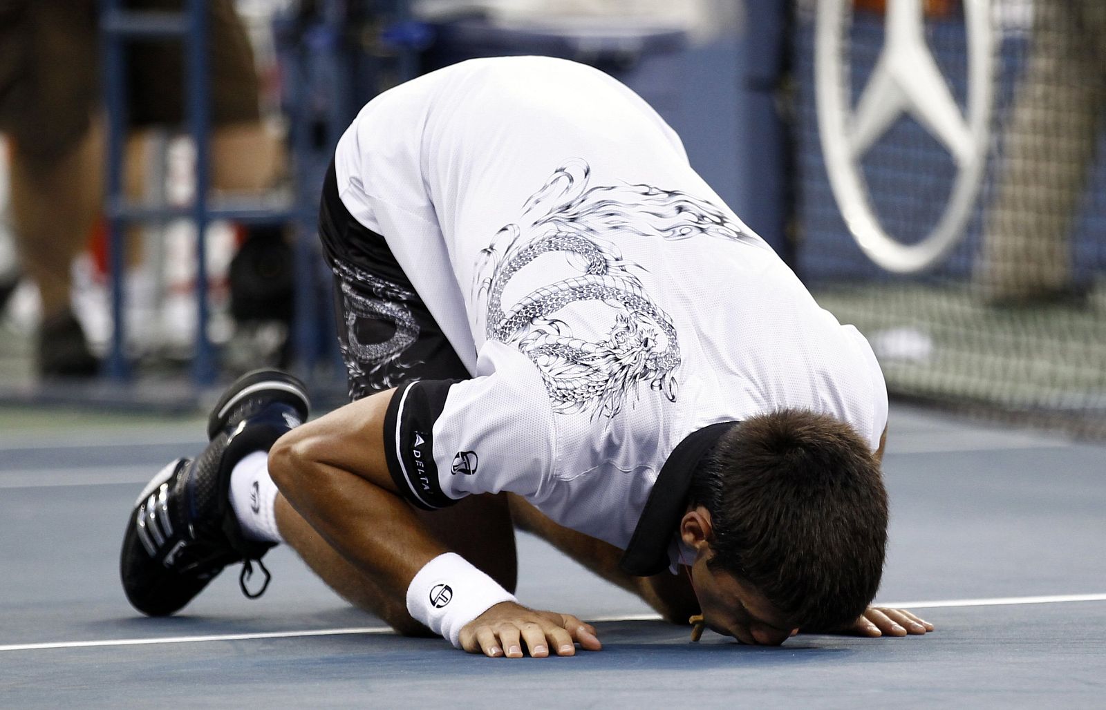 Novak Djokovic of Serbia kisses the court as he celebrates his victory against Roger Federer of Switzerland during the U.S. Open tennis tournament in New York
