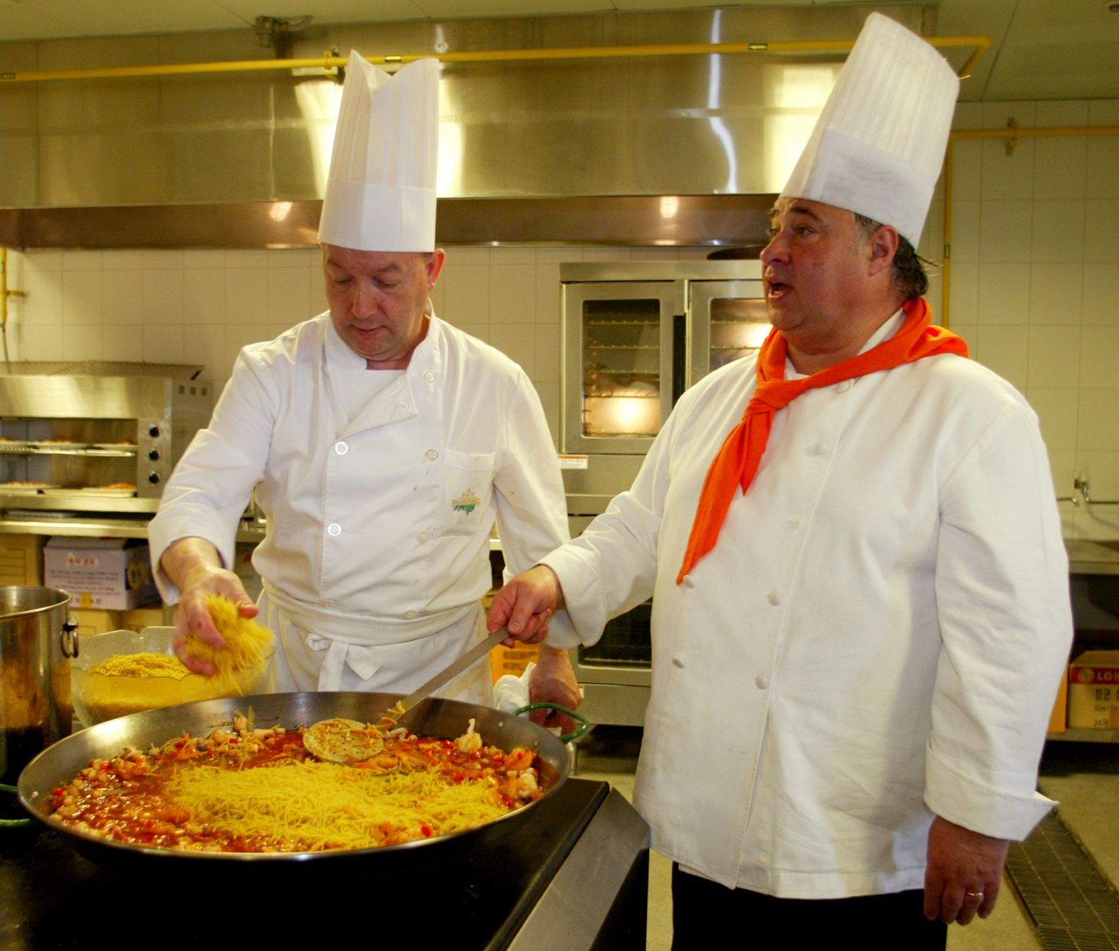 Dos cocineros preparan una fideuá