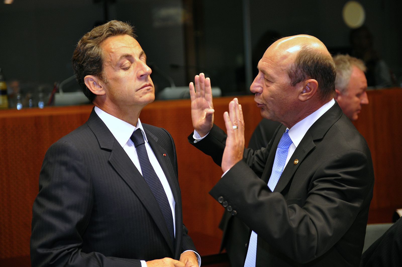 France's President Sarkozy listens to Romania's President Basescu at an EU leaders summit in Brussels