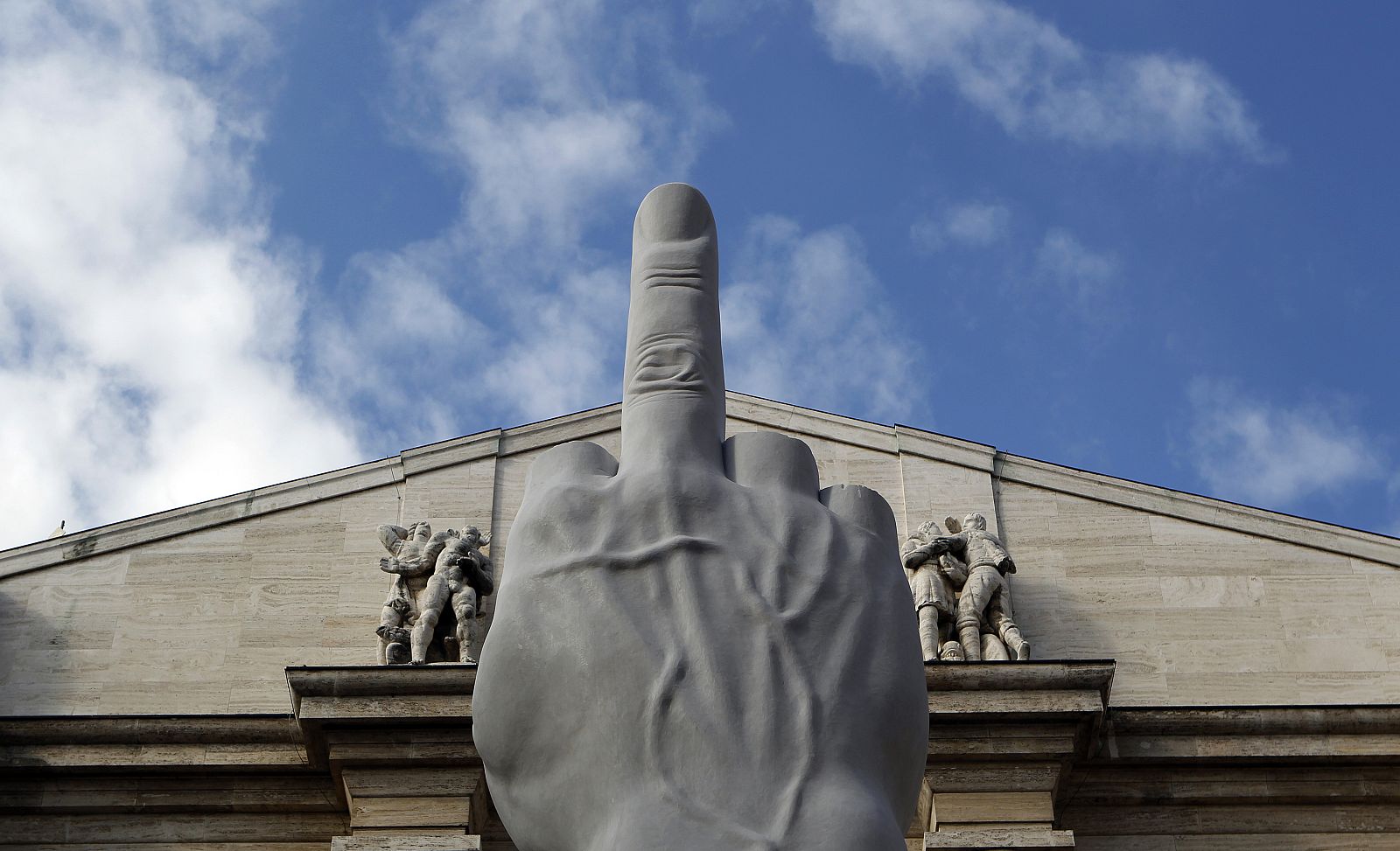 A sculpture called " crippled hand" from Italian sculptor Maurizio Cattelan is placed in front of stock exchange palace in Milan
