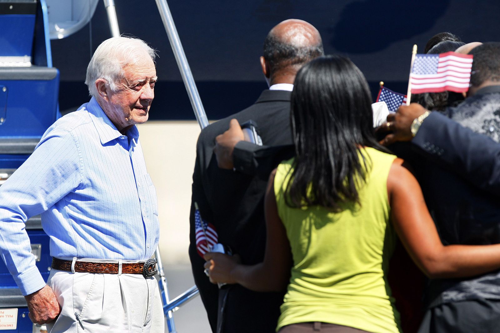 Former U.S. President Carter looks on as Mahli Gomes is reunited with his family in Boston