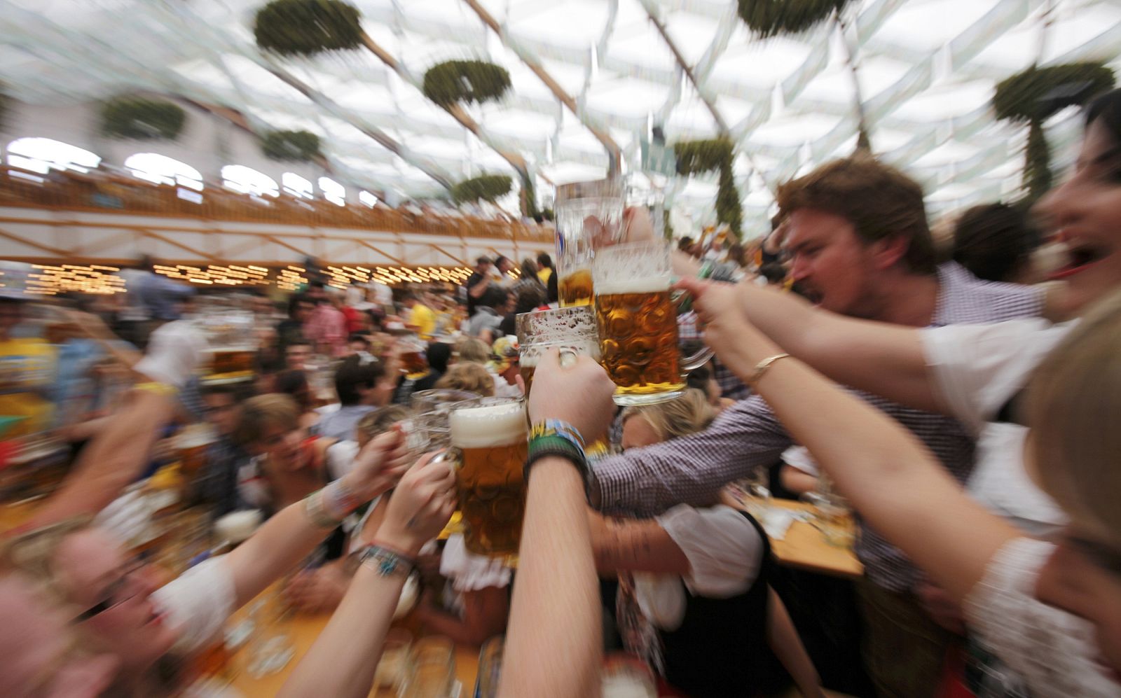 People wearing traditional Bavarian clothes toast with beer during the opening day of the 177th Oktoberfest in Munich