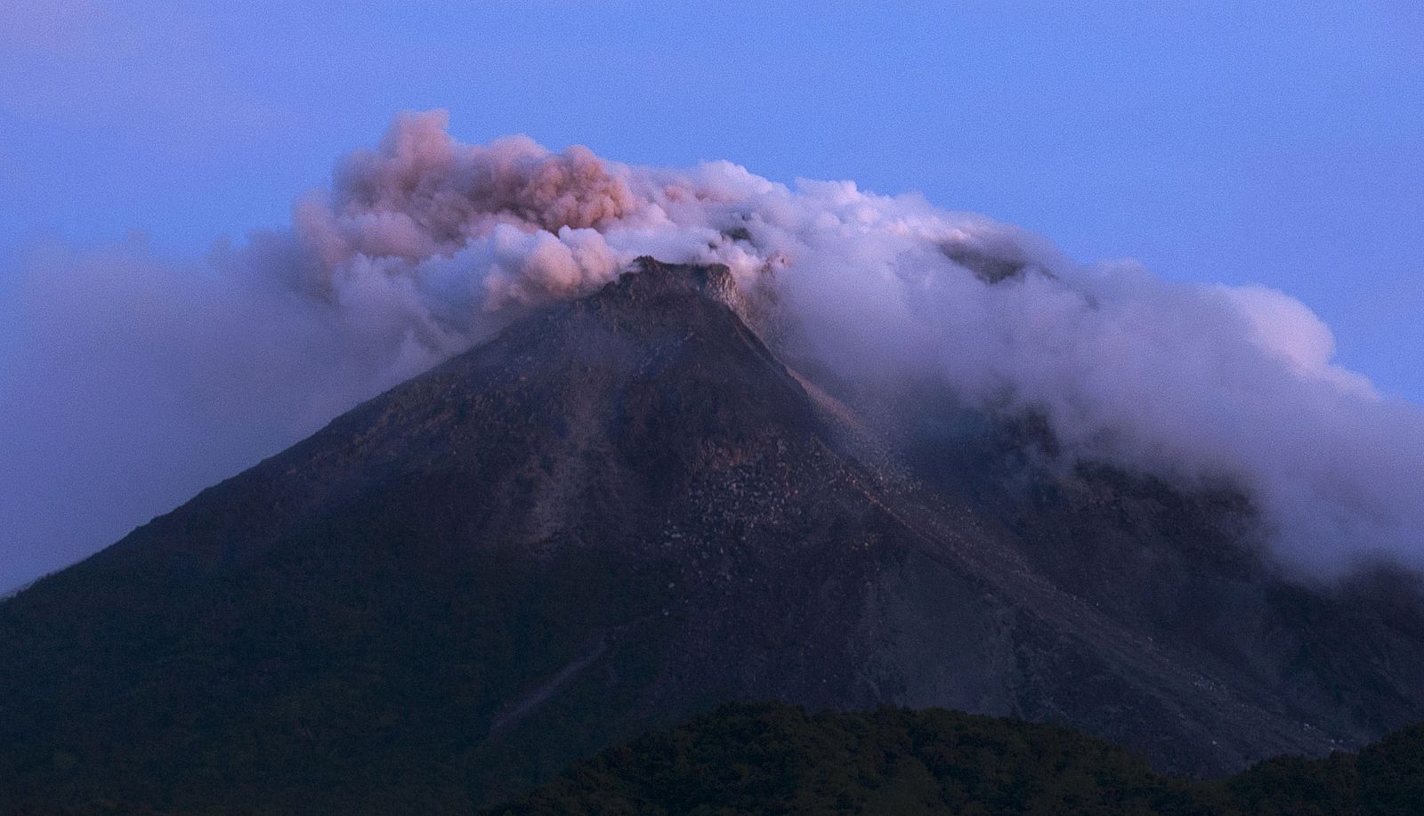 Mount Merapi emits smoke as it is seen from Kali Tengah village near Yogyakarta