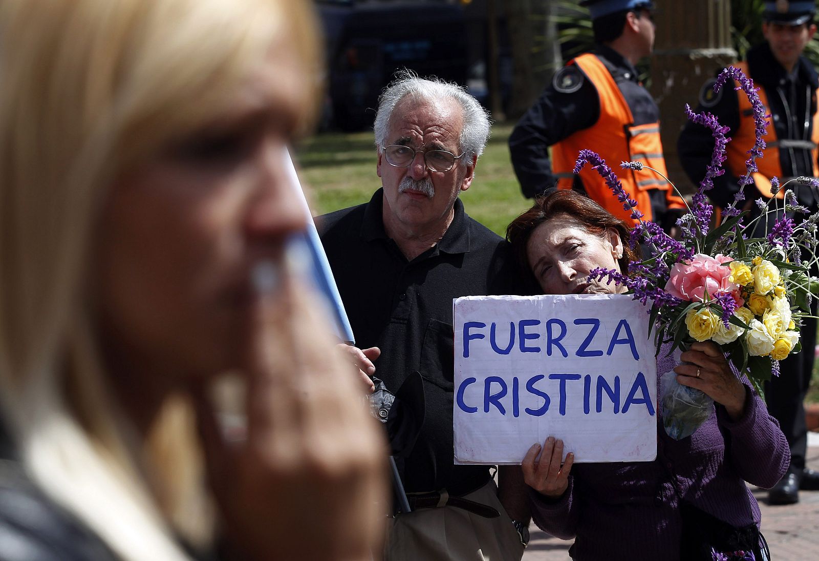 A woman holds a sign in support of President Fernandez de Kirchner as others react outside the Casa Rosada Presidential Palace in Buenos Aires