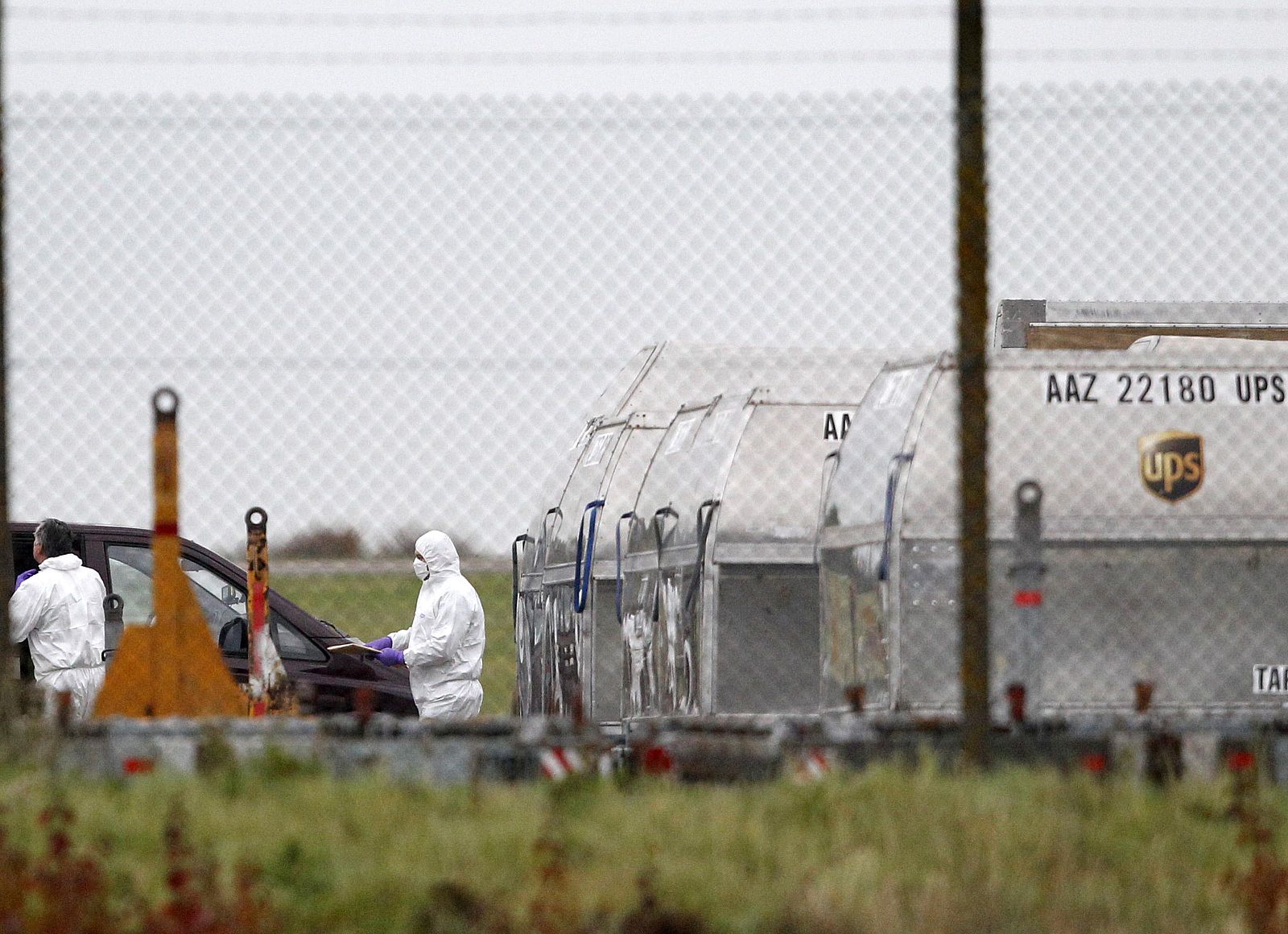 Forenses trasladan un paquete de un contenedor de UPS en el aeropuerto de East Midlands en el norte de Reino Unido.