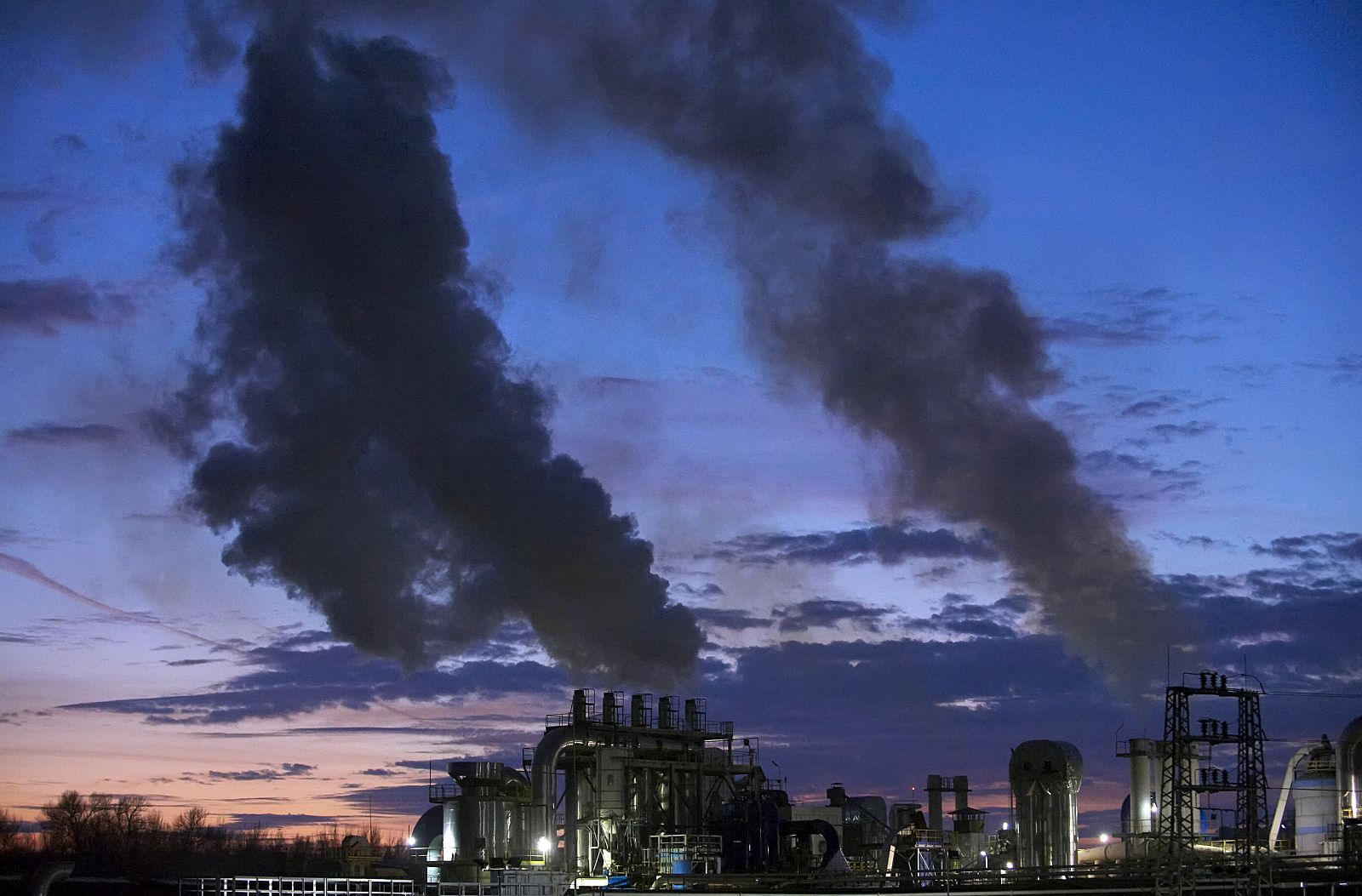 Smoke billows from the chimneys of a wood products factory near the city of Burgos