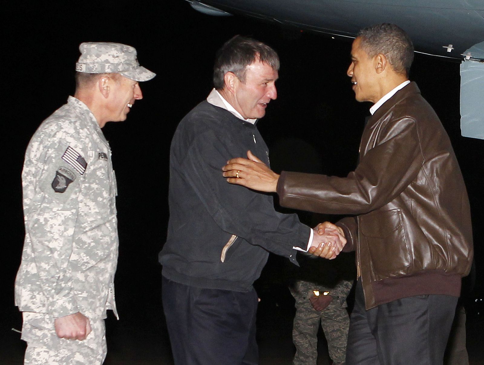 U.S. President Barack Obama is greeted by U.S. Ambassador to Afghanistan Karl Eikenberry and Commander of U.S. forces in Afghanistan General David Petraeus as he arrives at Bagram Air Base, Afghanistan