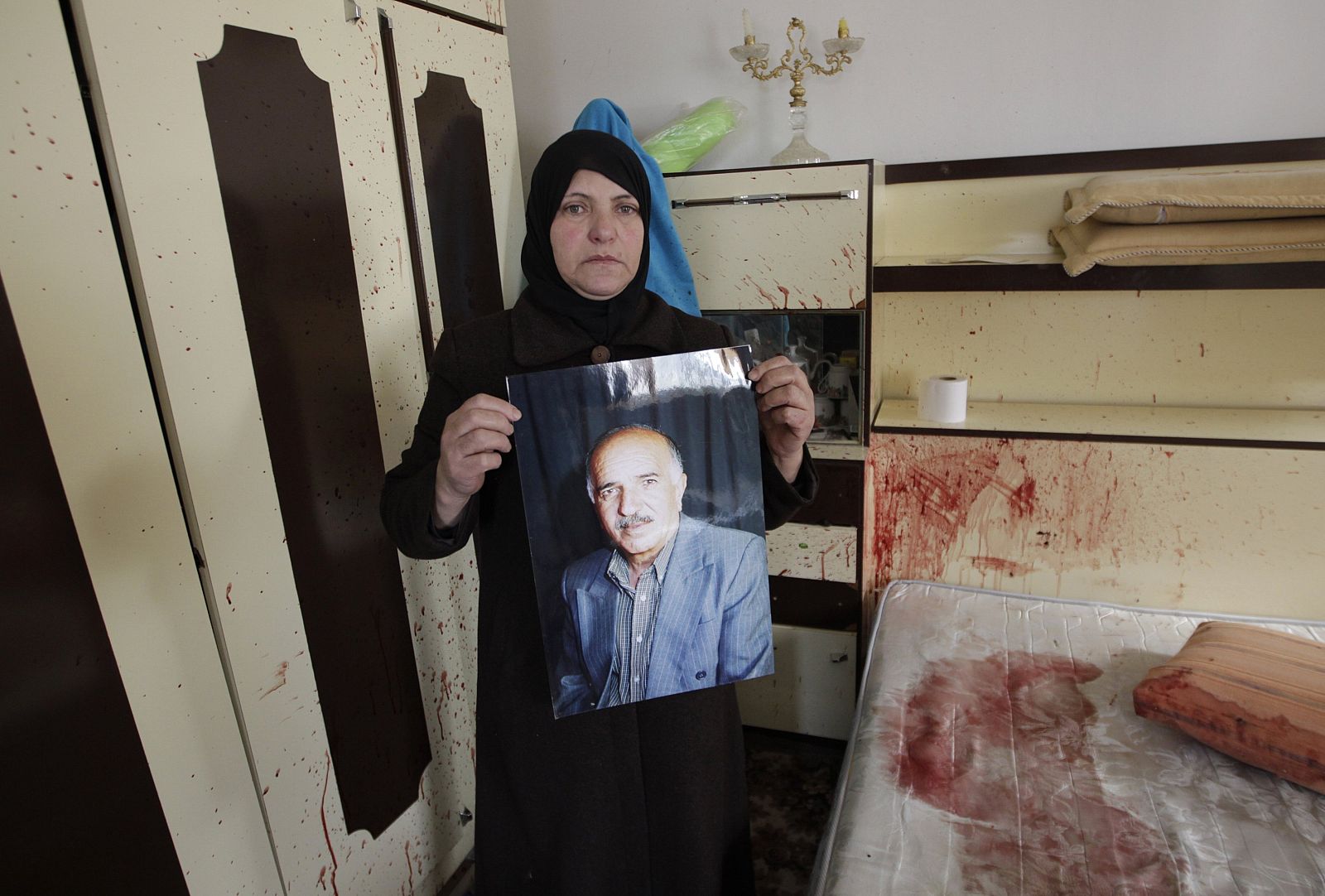 Sobheye, wife of Amr Qawasme, holds a photograph of her husband who was killed by Israeli troops, in Hebron