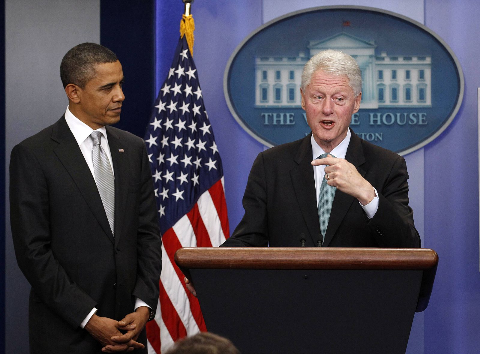 U.S. President Obama looks on as former President Clinton gestures while speaking to the press in the Brady Press Briefing Room at the White House in Washington