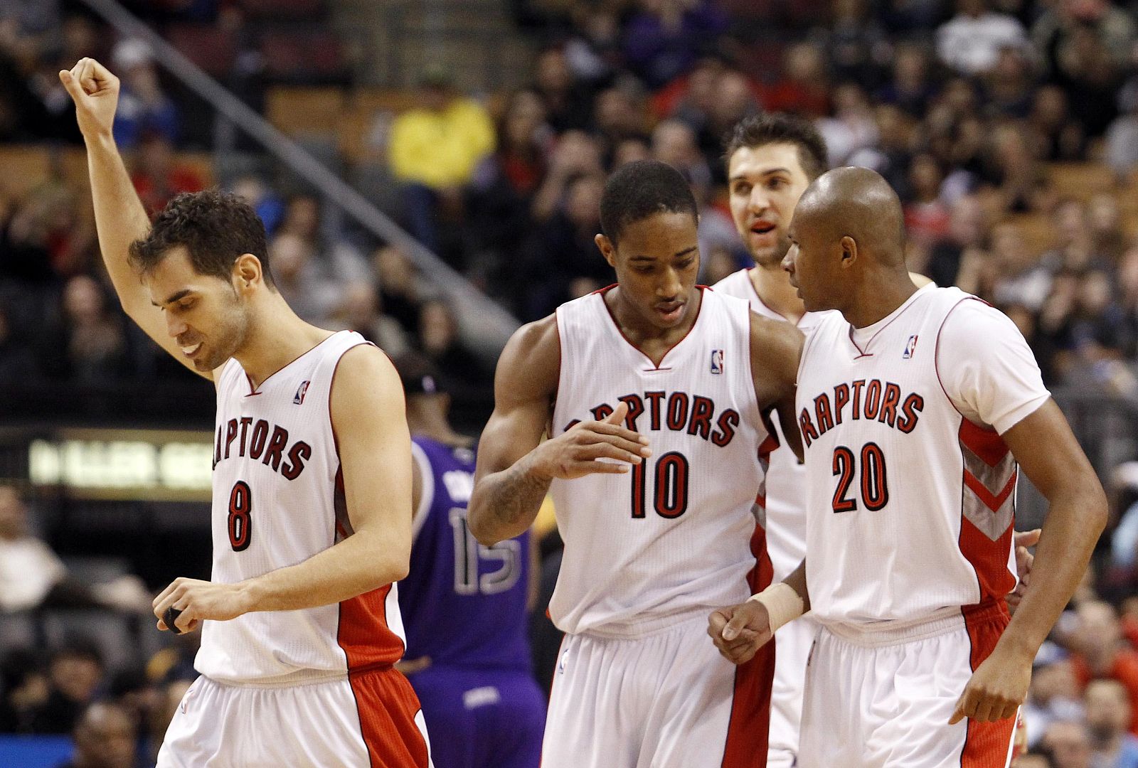 Raptors players Calderon, DeRozan, and Barbosa celebrate during a time-out during their NBA basketball game in Toronto