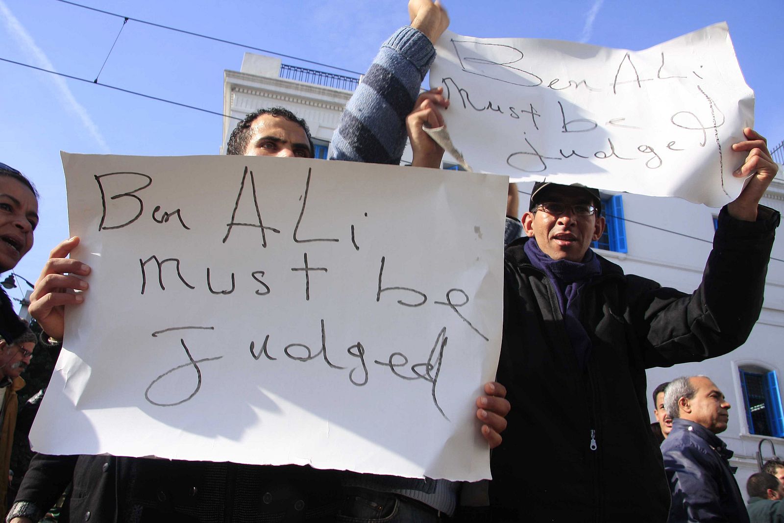 Tunisian demonstrators hold signs during demonstration in downtown Tunis