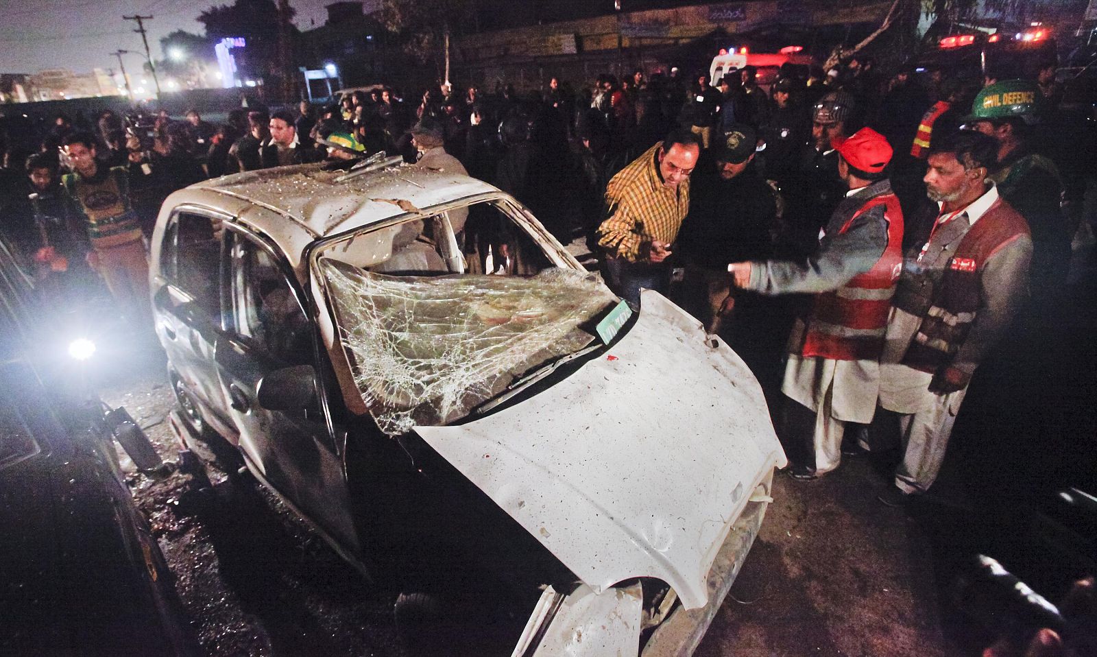 Police and rescue officials stand at the site of a suicide bomb attack in Lahore Pakistan