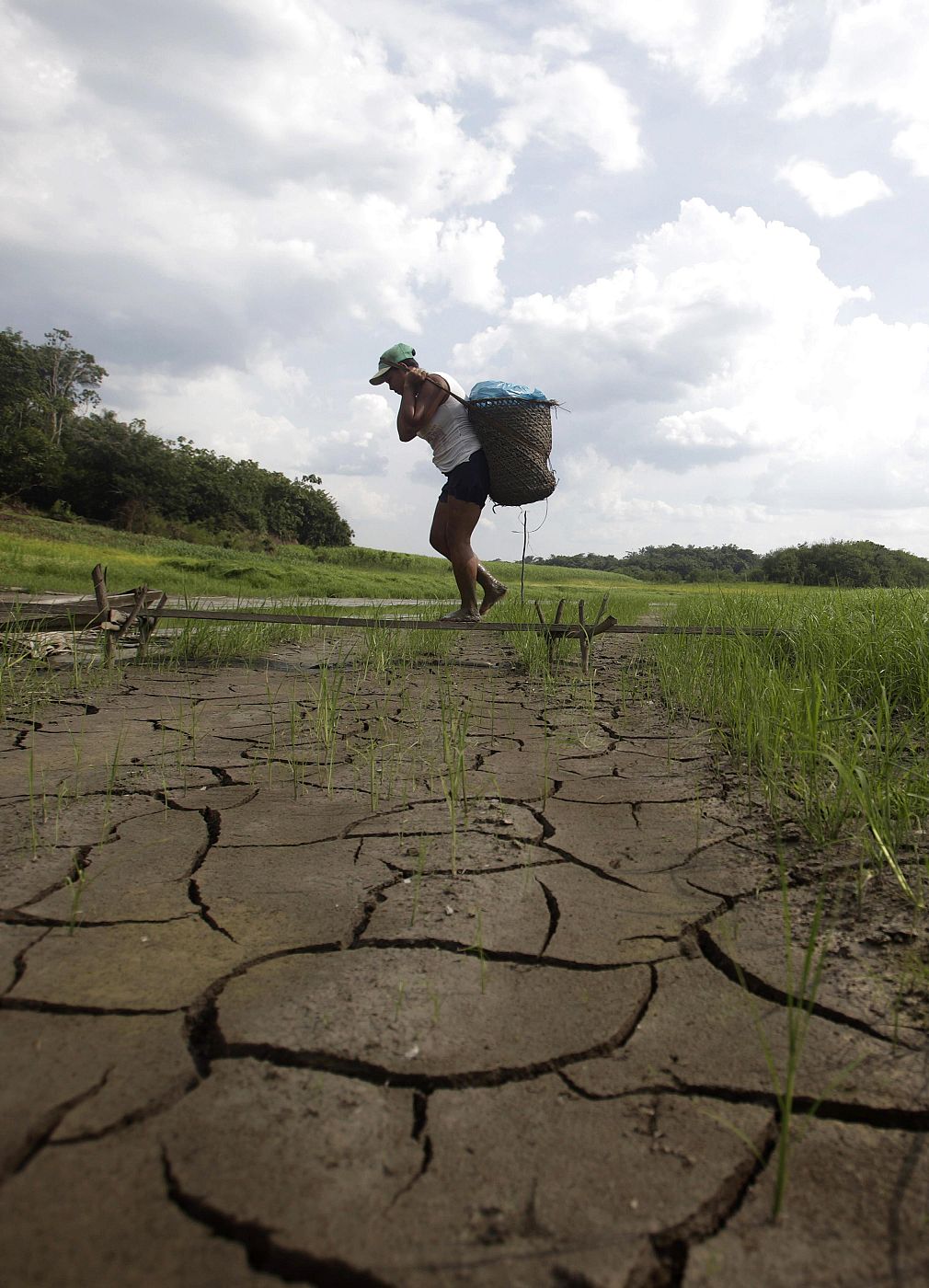 File photo of a woman carries goods over a dried-up area of Caapiranga lake, in Caapiranga, in Amazonas state, northern Brazil