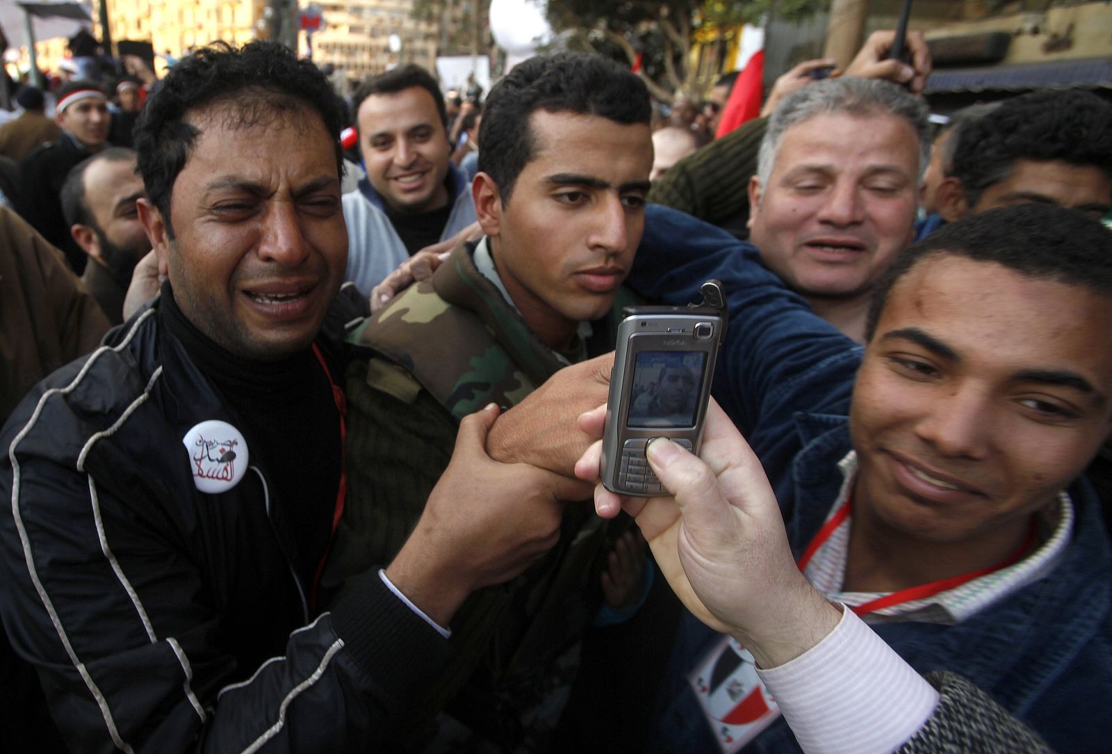 A tearful opposition supporter holds an Egyptian army officer after commander, Hassan al-Roweny, addressed protesters in the opposition stronghold of Tahrir Square, in Cairo