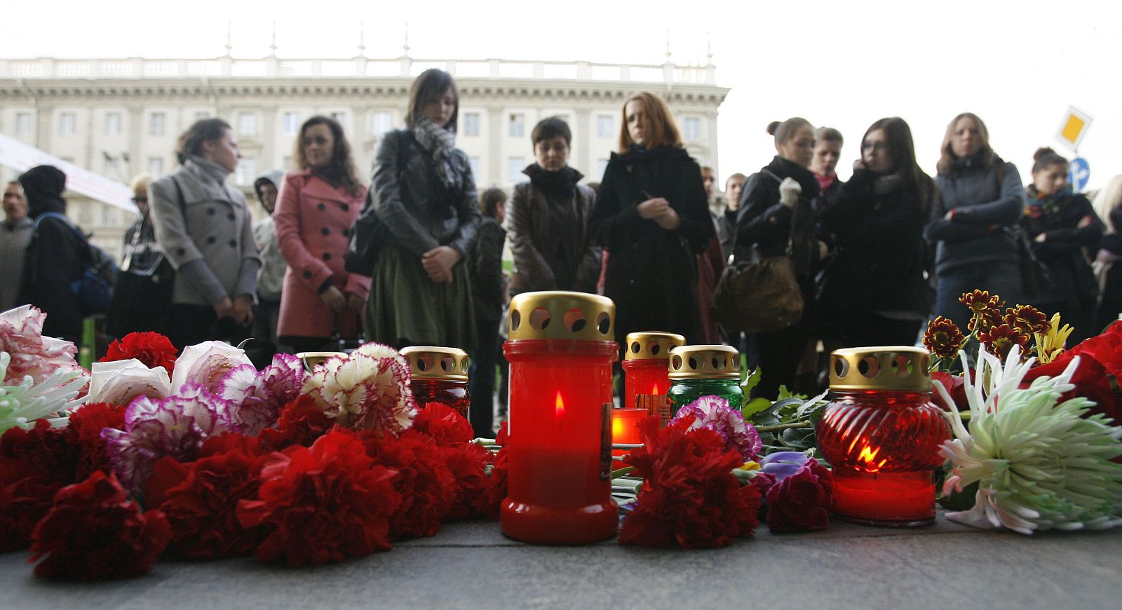 Un grupo de personas deja flores ante la estación de metro de Oktyabrskaya, en Minsk