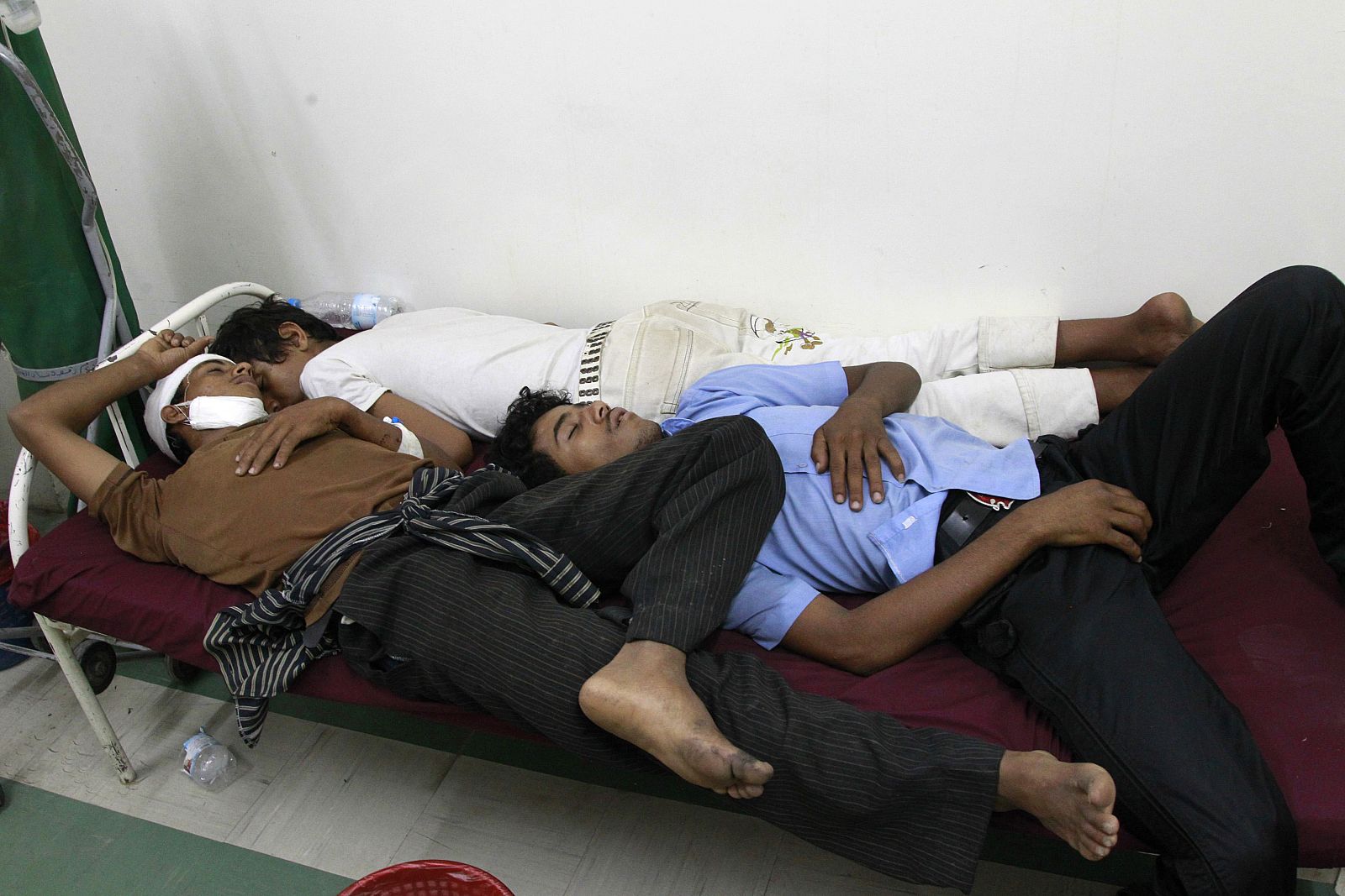Wounded anti-government protesters lie on a bed at a hospital after clashes with police in the southern Yemeni city of Taiz