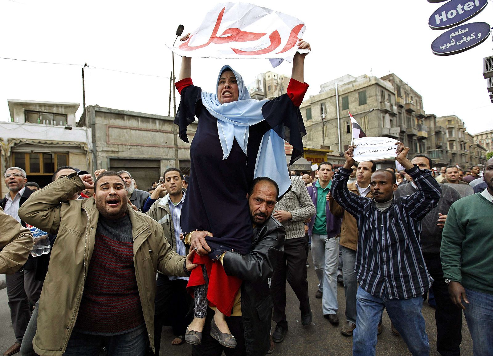 A protester lifts another as they chant anti-government slogans during mass demonstrations against Egypt's President Mubarak in Alexandria
