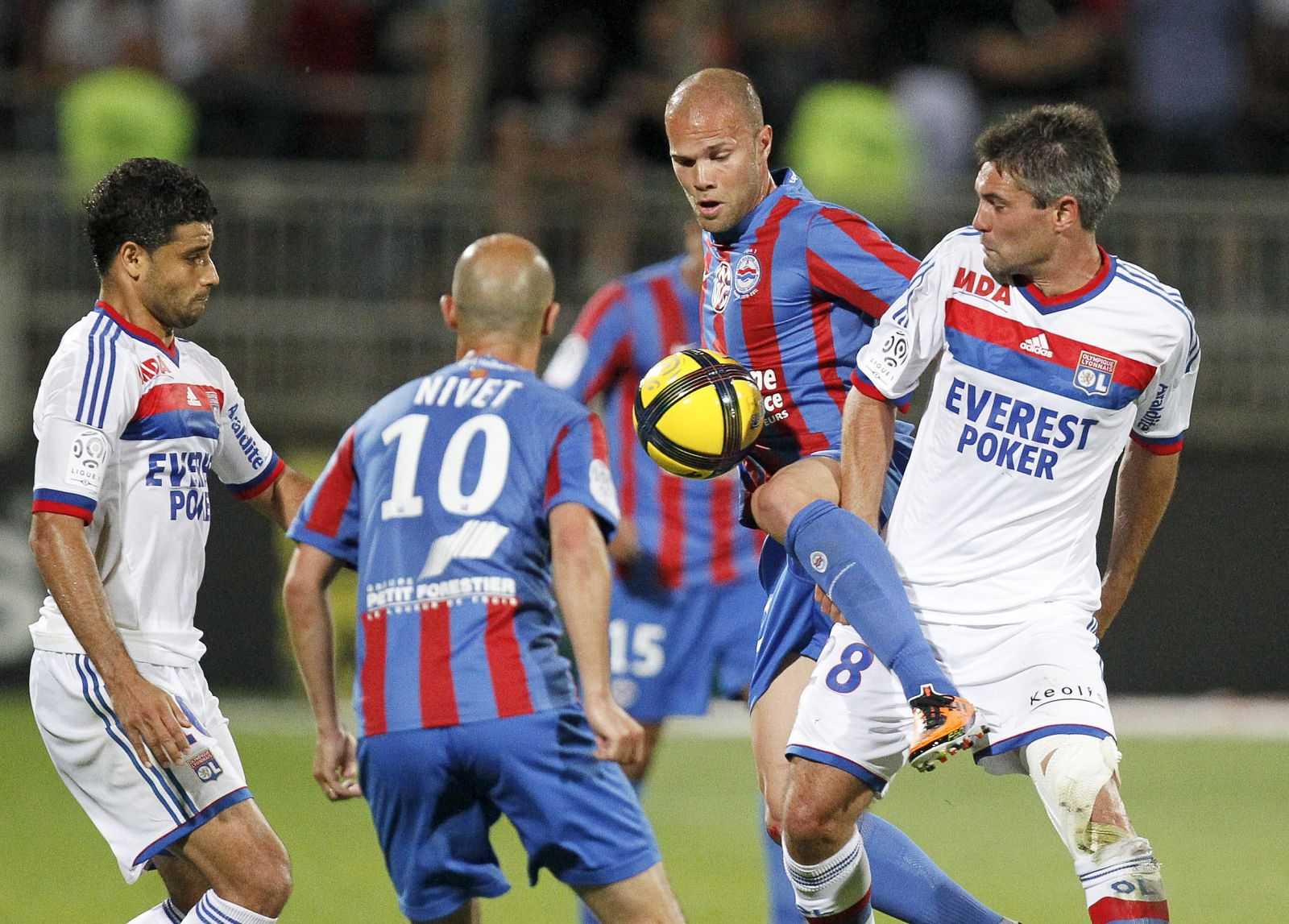 Olympique Lyon's Toulalan challenges Raineau of Caen during their French Ligue 1 soccer match at the Gerland stadium