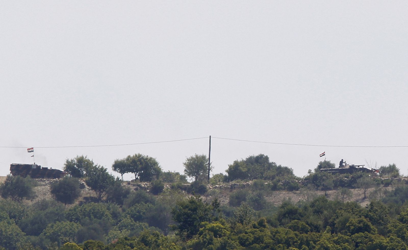 Vehículos acorazados sirios en las colinas junto a la frontera, no lejos de la localidad turca de Guvecci